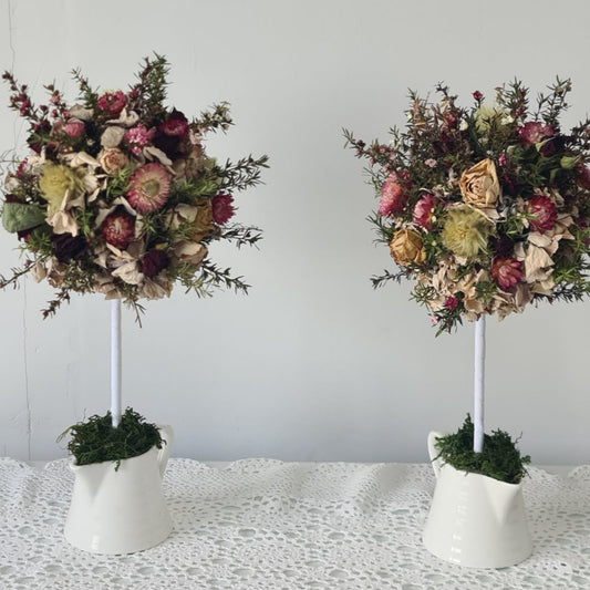 Two floral arrangements in white pots 
