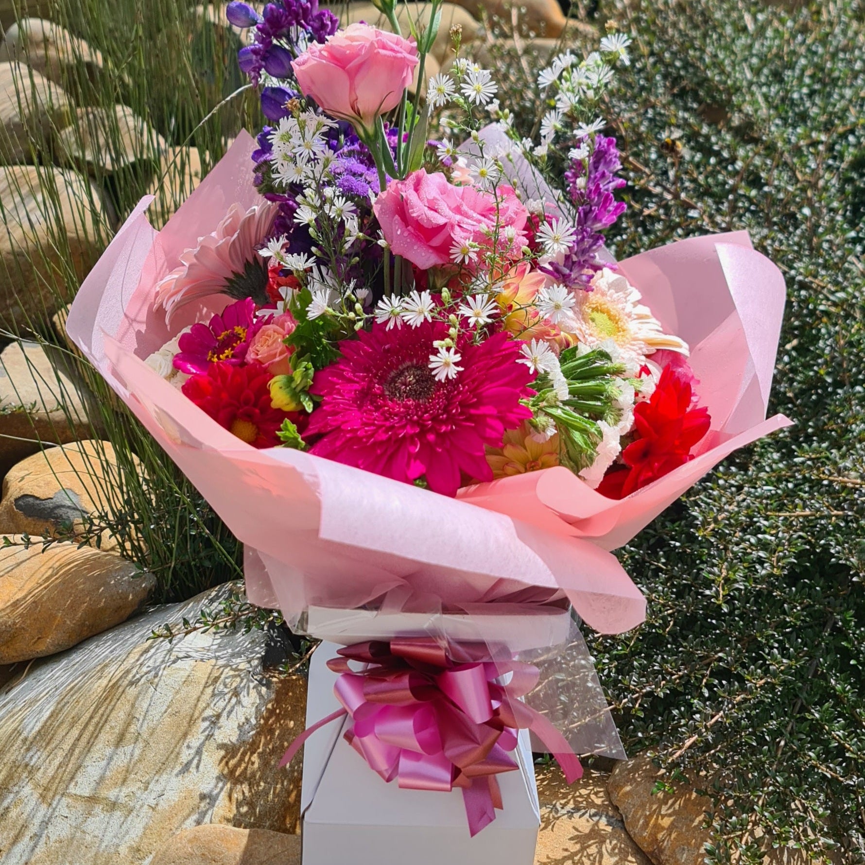 Bouquet of colorful flowers wrapped in pink paper in a Box Vas