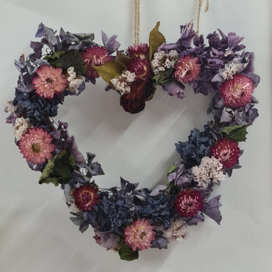 Heart-shaped floral wreath with purple, pink, and green flowers made to order