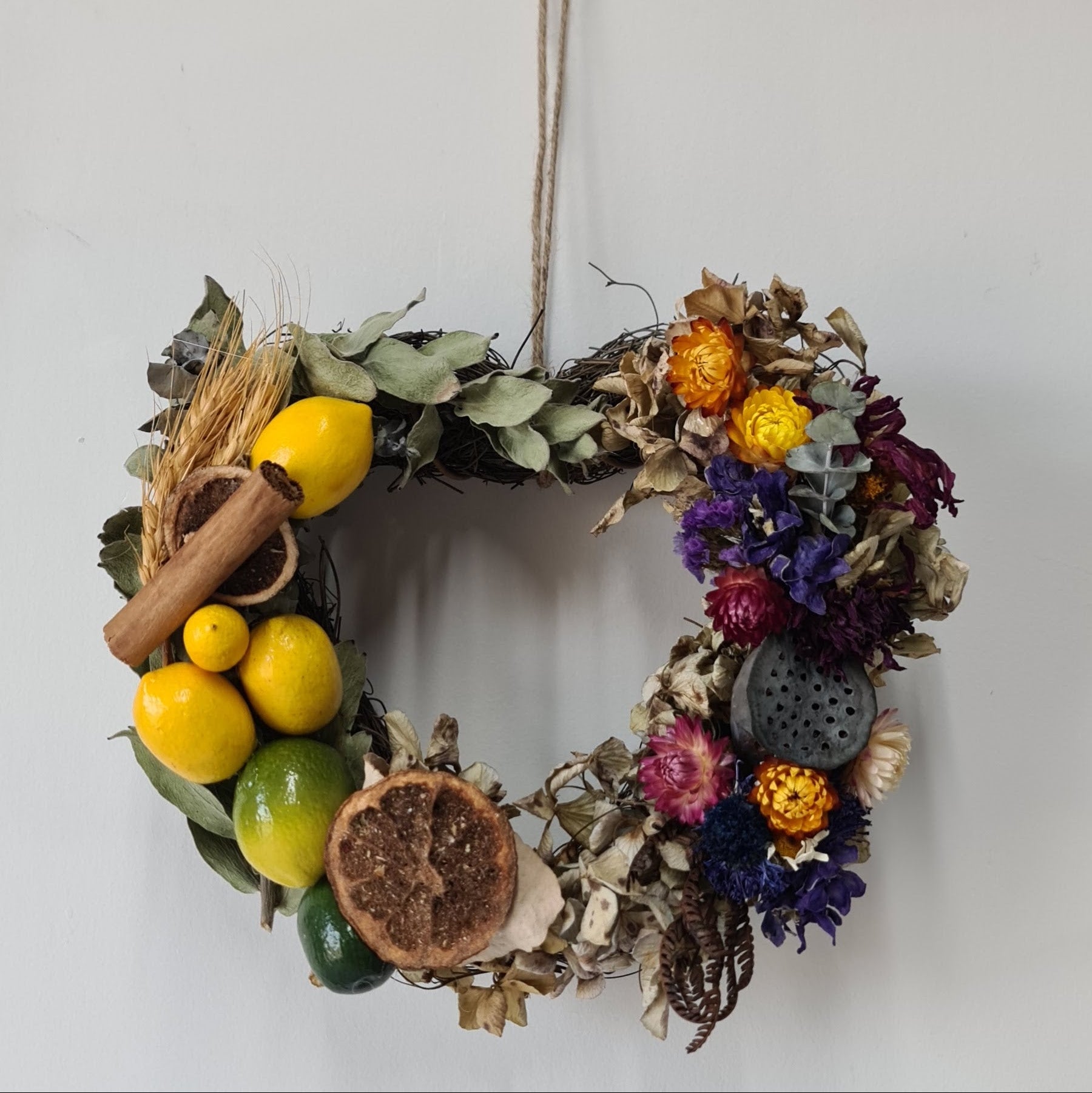 Decorative wreath with fruits, flowers, and herbs